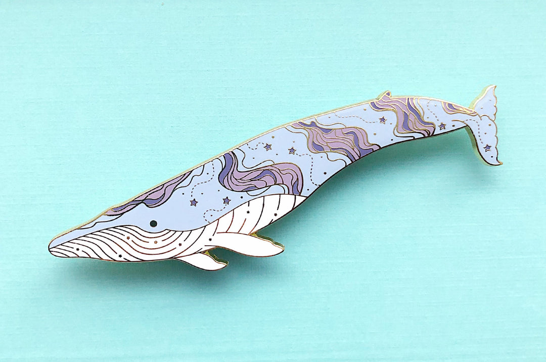 Large blue whale enamel pin with nebula and stars design along its body
